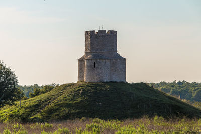 Built structure on field against sky