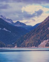 Scenic view of lake in front of mountains against cloudy sky