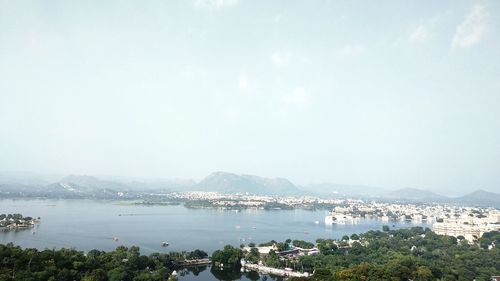 High angle view of city by sea against sky