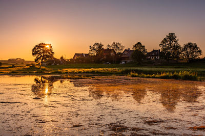 Scenic view of lake against sky at sunset