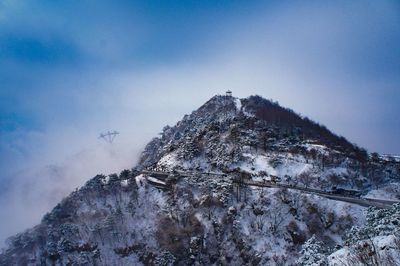 Low angle view of snow covered mountain against sky