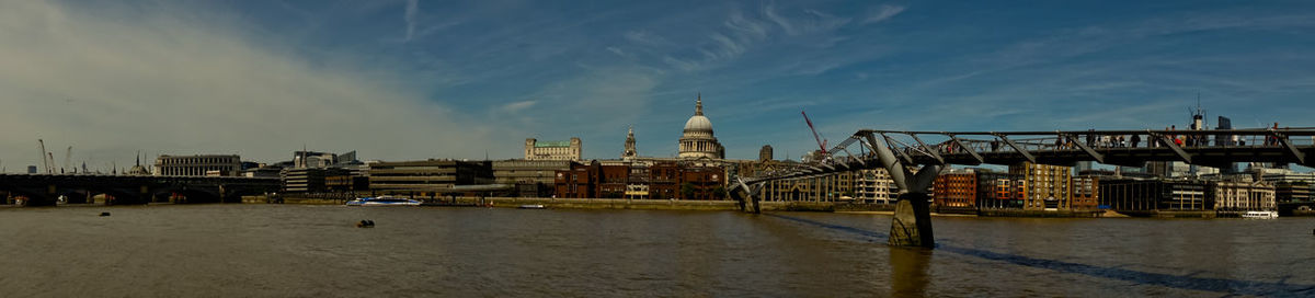 View of buildings at waterfront against cloudy sky