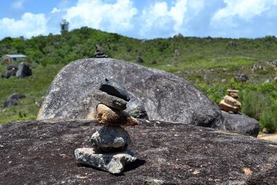 Close-up of stone stack on rock against sky