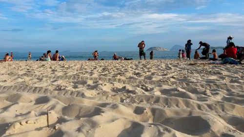 People at beach against sky