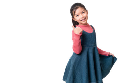 Portrait of smiling girl standing against white background