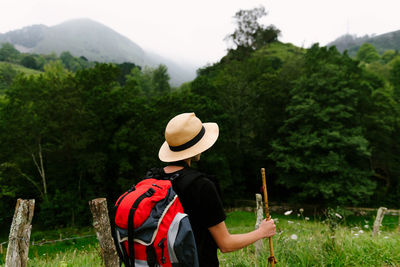 Rear view of man wearing hat against trees