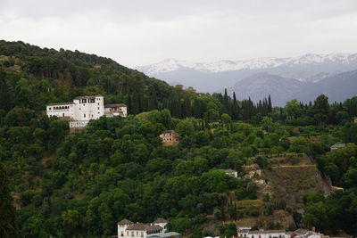 Scenic view of townscape by mountains against sky