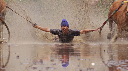 Full length of smiling young man in water