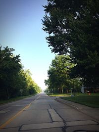 Empty road along trees