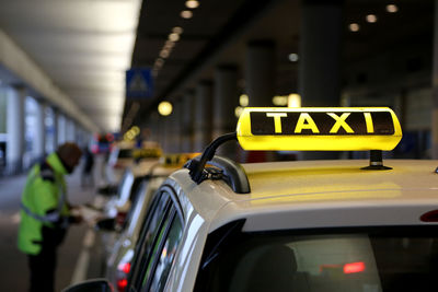 Close-up of yellow sign on taxi roof