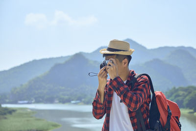 Midsection of person standing by mountains against sky