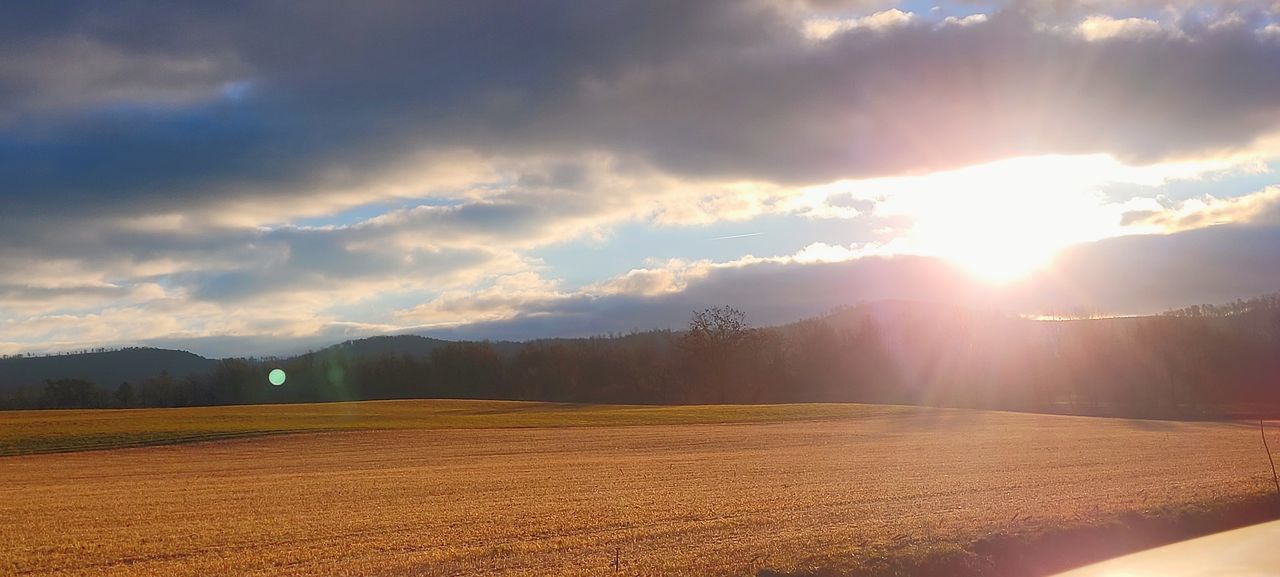 sky, morning, horizon, landscape, environment, cloud, sunrise, dawn, nature, sunlight, sun, land, beauty in nature, scenics - nature, sunbeam, lens flare, plant, tranquility, rural scene, no people, field, tree, mountain, tranquil scene, outdoors, idyllic, agriculture, summer, dramatic sky, day, travel, plain, non-urban scene, back lit, forest