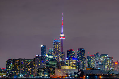 Illuminated buildings in city against sky at night