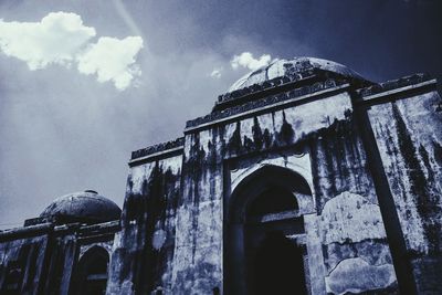 Low angle view of old building against cloudy sky