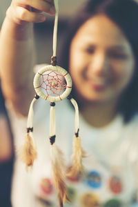 Close-up of young woman holding dreamcatcher