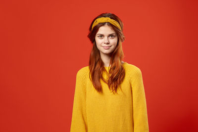 Portrait of woman against red background