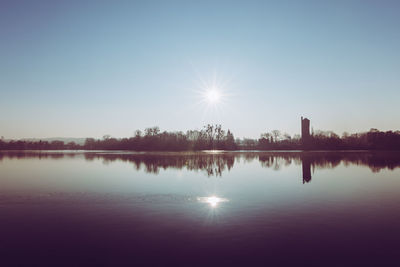 Scenic view of lake against clear sky during sunset