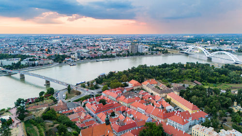 High angle view of townscape by sea against sky during sunset