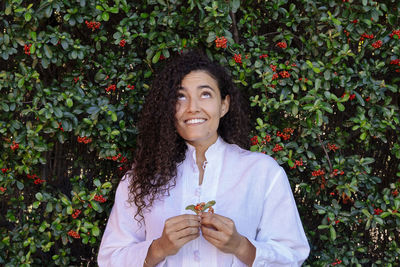 Smiling woman standing by plants