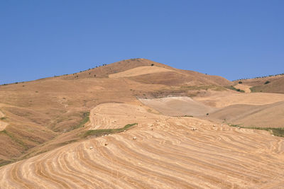 Scenic view of desert against clear blue sky