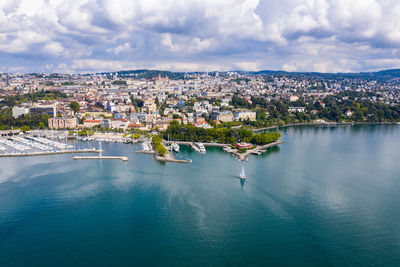 High angle view of townscape by sea against sky