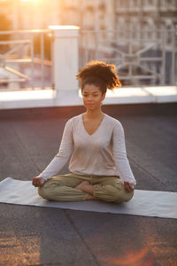 Full length of teenager girl meditating outdoors