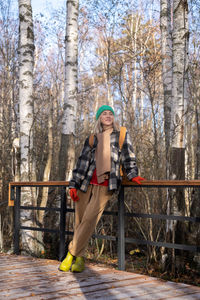 Smiling middle aged woman hiker resting in autumn park enjoying scandinavian nature.