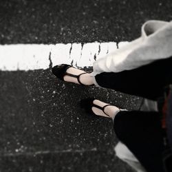 Low section of woman walking on road