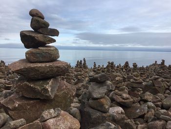 Stack of stones on beach against sky