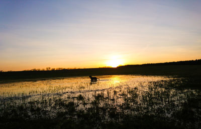 Scenic view of lake against sky during sunset