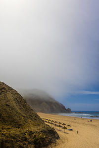 Scenic view of beach against foggy sky