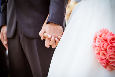 Midsection of couple holding hands