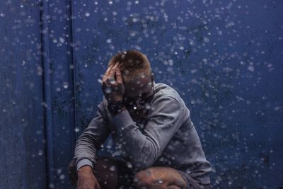 Water falling with man crouching in background