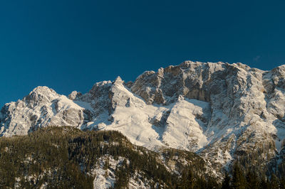 Scenic view of snowcapped mountains against clear blue sky