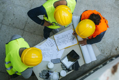 Woman and two men in workwear discussing construction plan