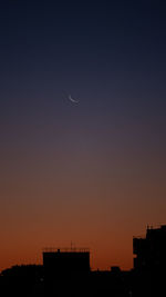 Silhouette buildings against sky at night