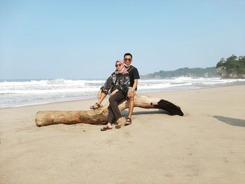 Full length of young man on beach against sky