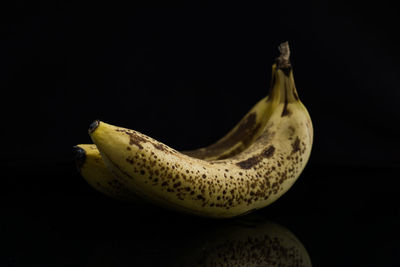 Close-up of bananas on table against black background