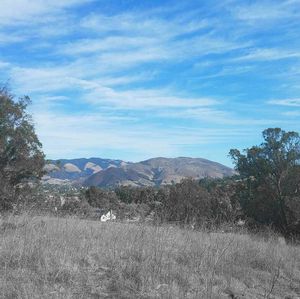 Distant view of countryside landscape against mountain range