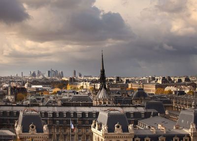 Cityscape against cloudy sky