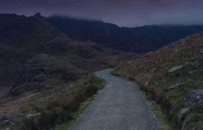 Scenic view of road amidst mountains against sky