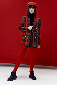 Portrait of a young woman against red background