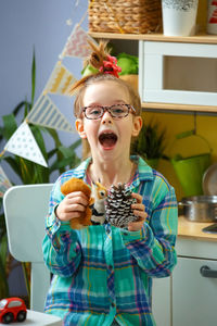 Portrait of girl holding toys at home