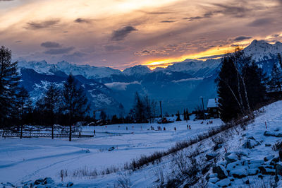 Scenic view of snow covered mountains against sky during sunset