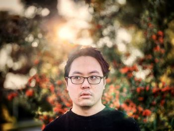 Portrait of mature man wearing eyeglasses against trees