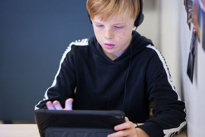 Boy using digital tablet in classroom