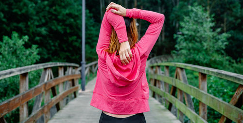 Rear view of woman standing on footbridge