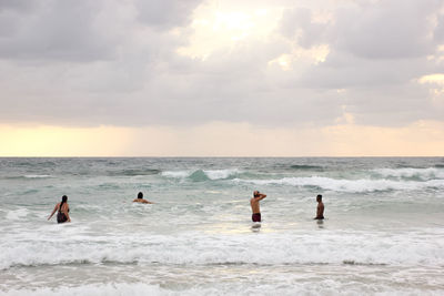 People on beach against sky