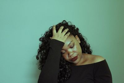 Close-up portrait of young woman against gray background