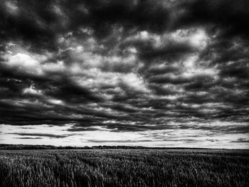 Scenic view of field against cloudy sky